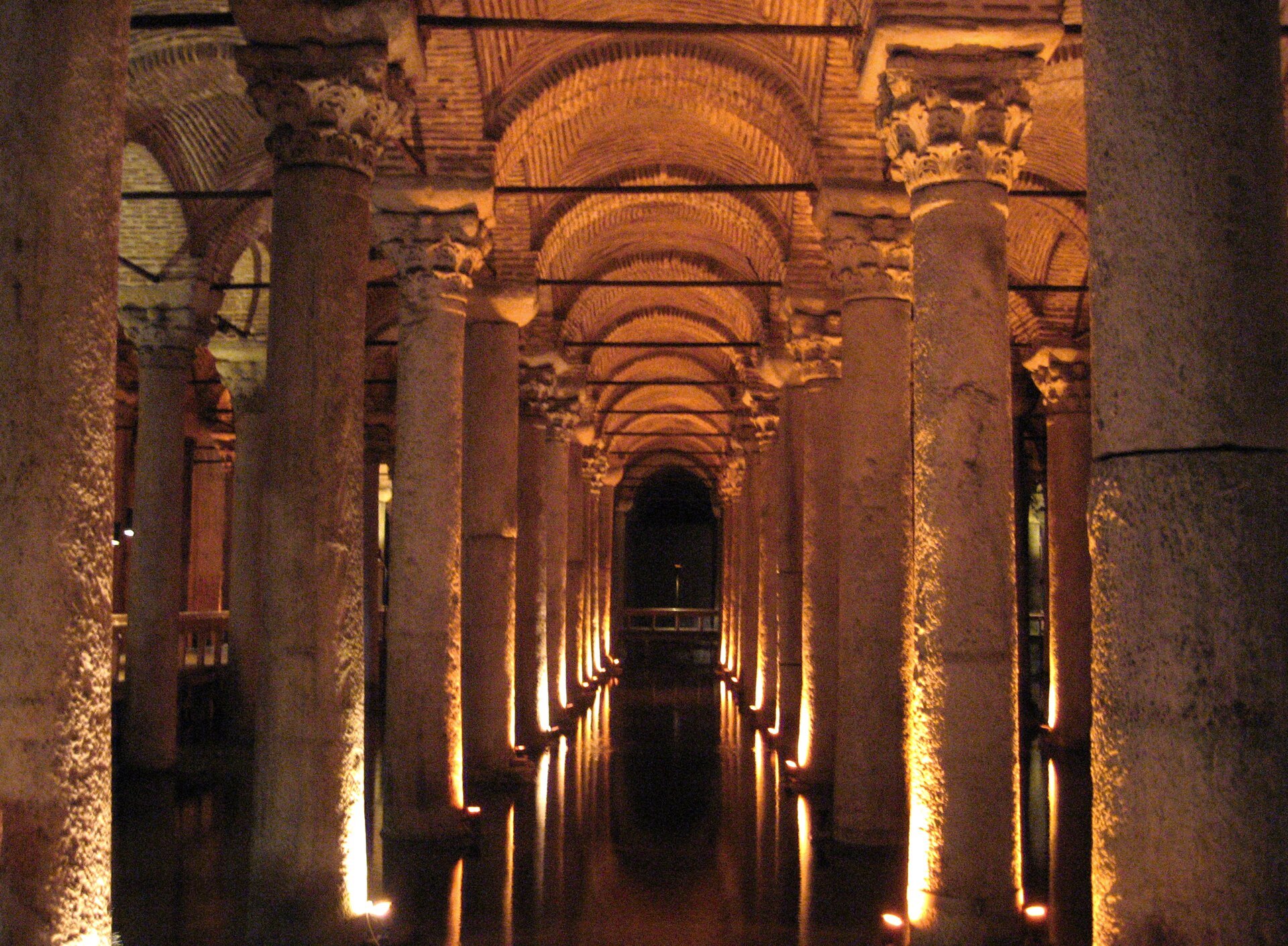 The Basilica Cistern's forest of columns receding into the dark, lit orange and reflected in shallow water