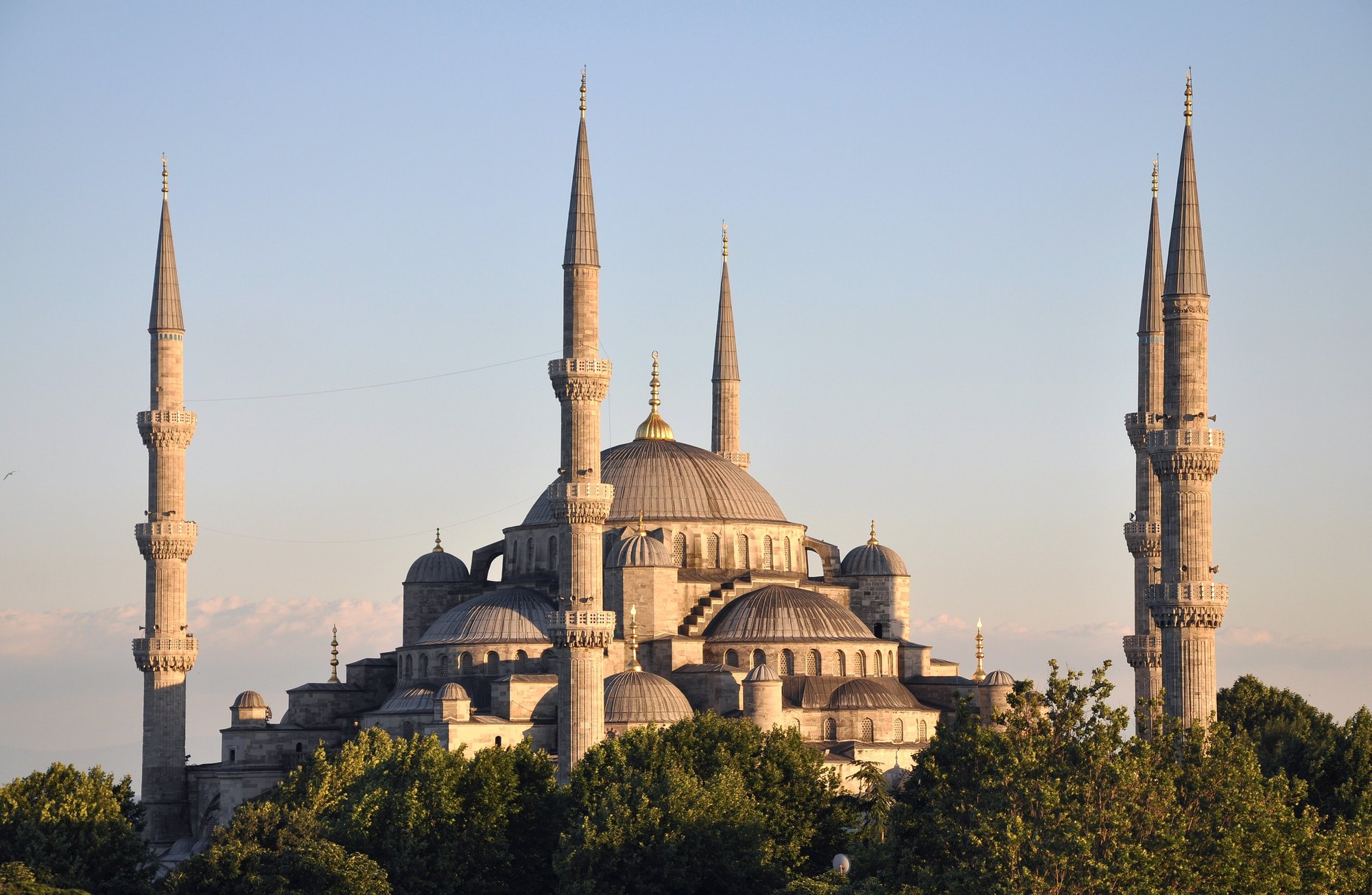 The Blue Mosque from the gardens in low evening light, its cascade of domes and six minarets