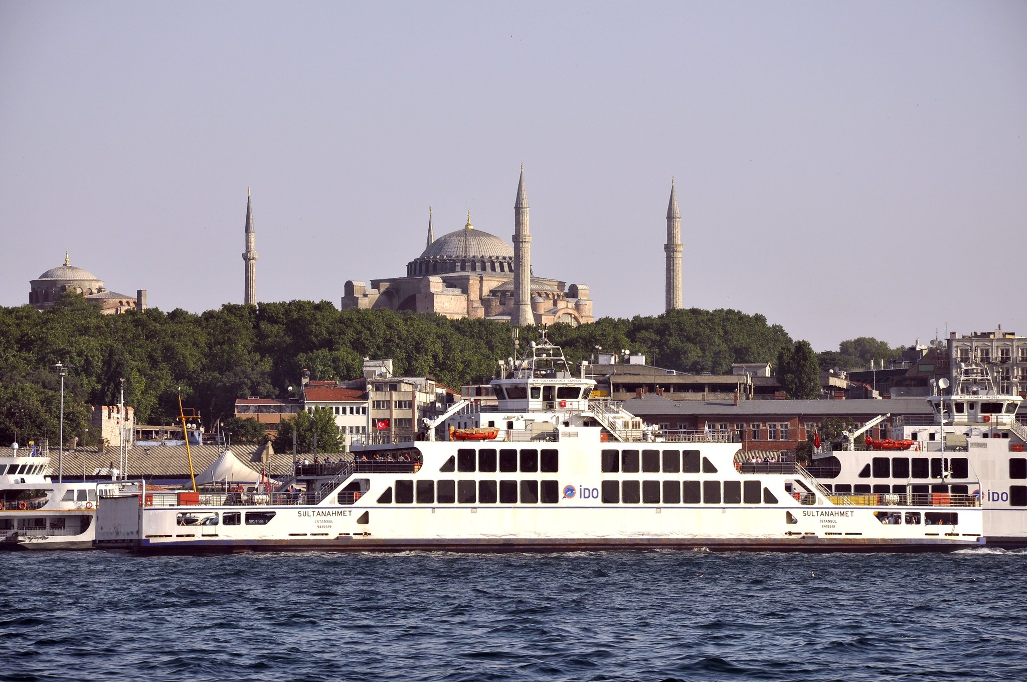 A commuter ferry crossing in front of Hagia Sophia, the old city rising behind it