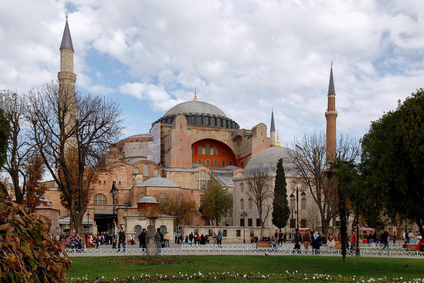 Visitors crossing the park in front of Hagia Sophia in autumn, giving a sense of the building's scale