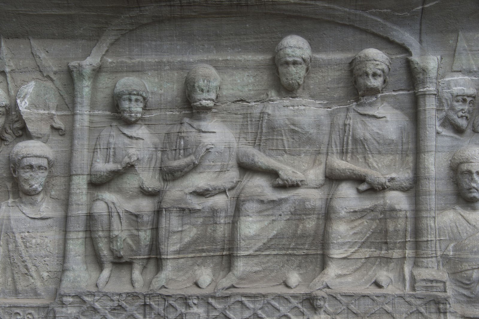 The carved marble base of the obelisk, rows of figures watching from the imperial box