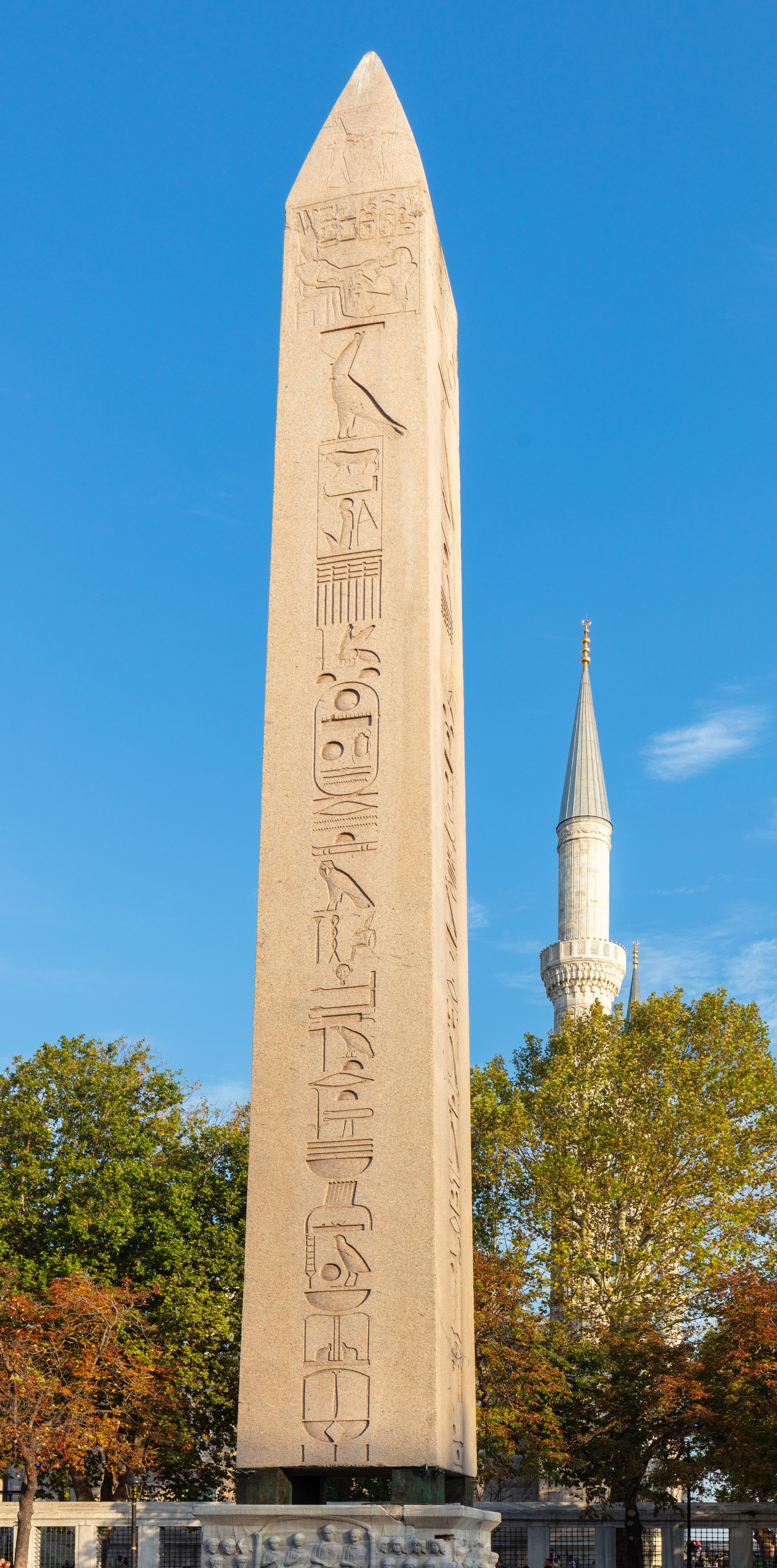 The obelisk against an open sky, with autumn trees around the square