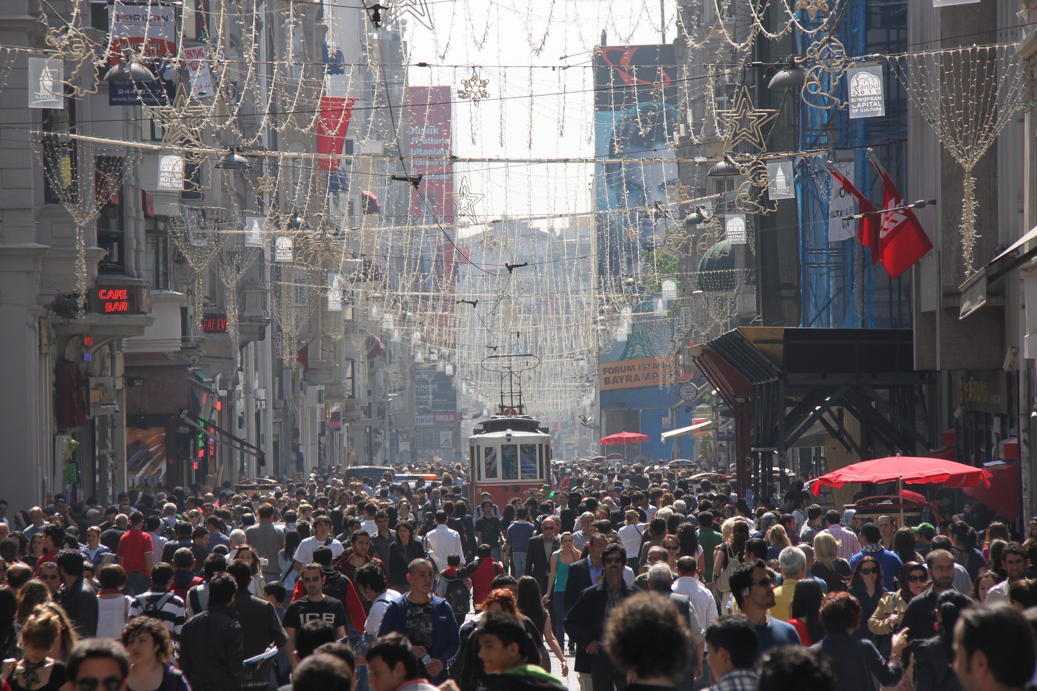 Istiklal Avenue packed shoulder to shoulder with people, the street running away between tall facades