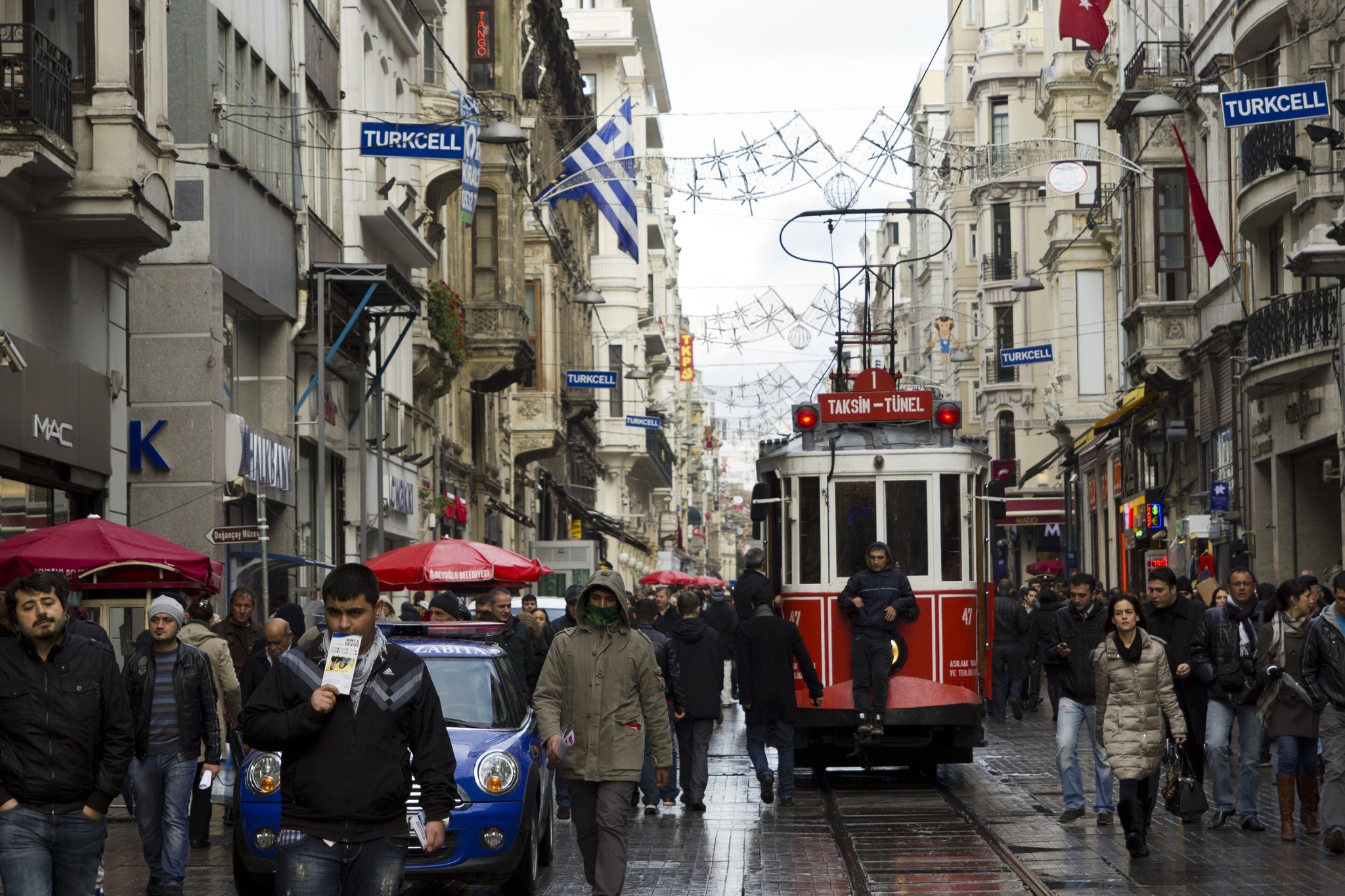 Istiklal Avenue in the evening, the tram lit and flags strung above the street
