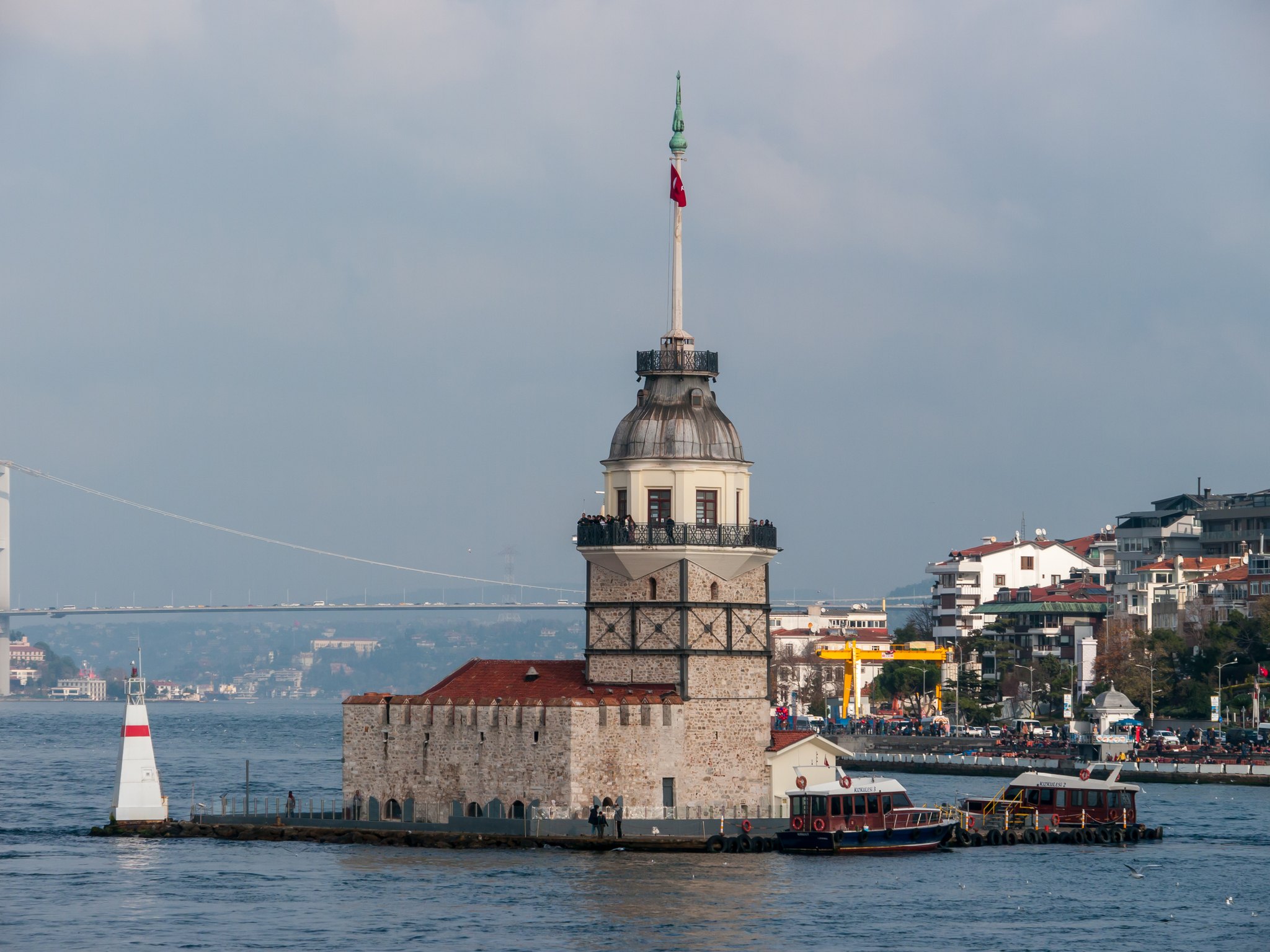 The Maiden's Tower close to, its white walls and red roof rising straight out of the water