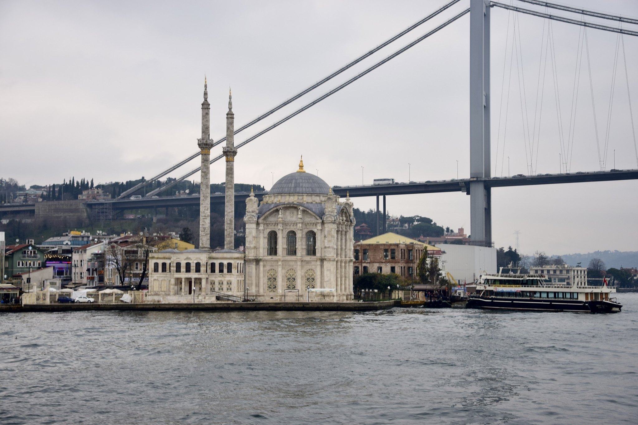 Ortakoy Mosque at the water's edge with the Bosphorus Bridge rising directly behind it
