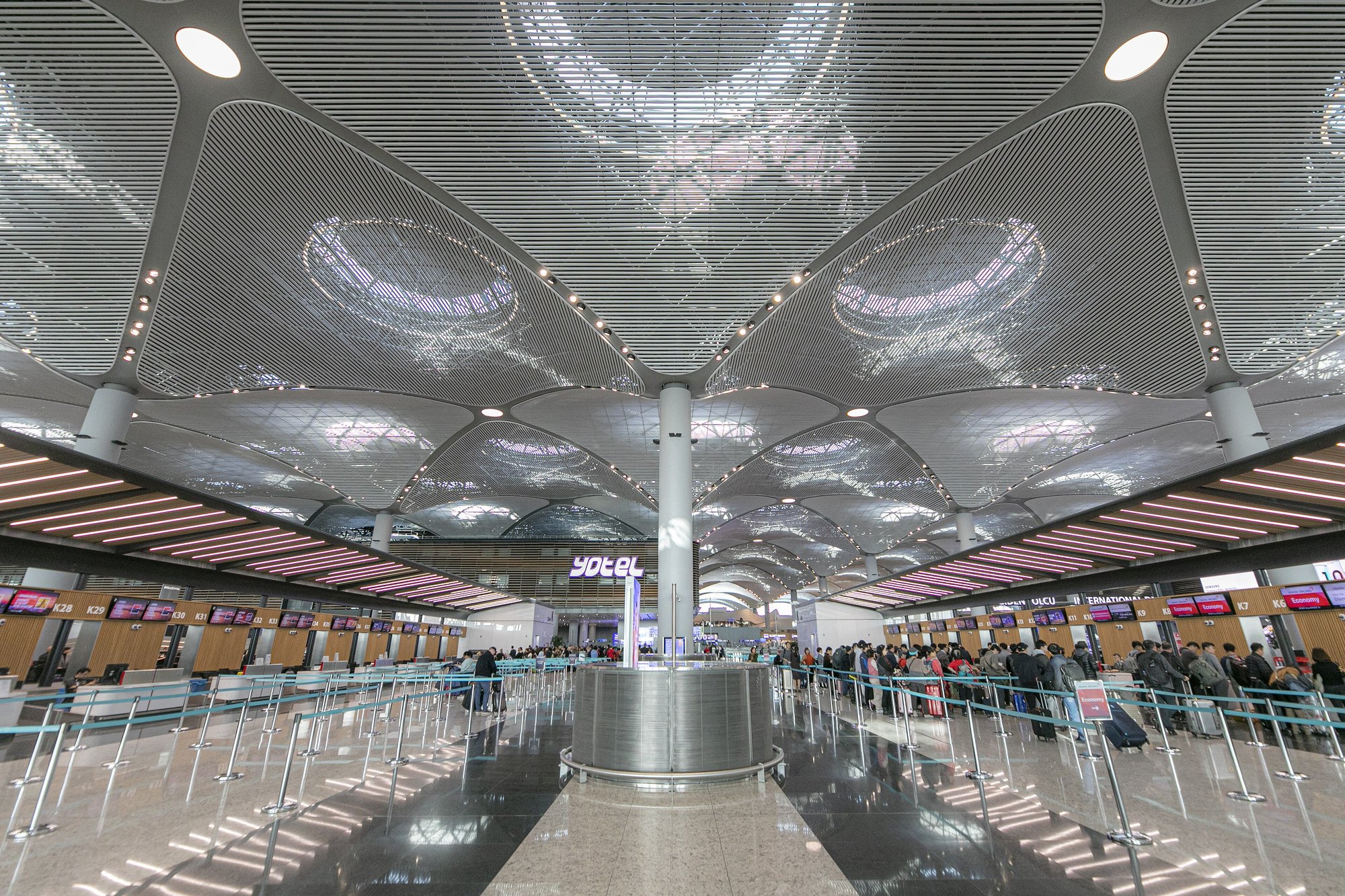 Rows of empty check-in desks at Istanbul Airport under the wave-form ceiling