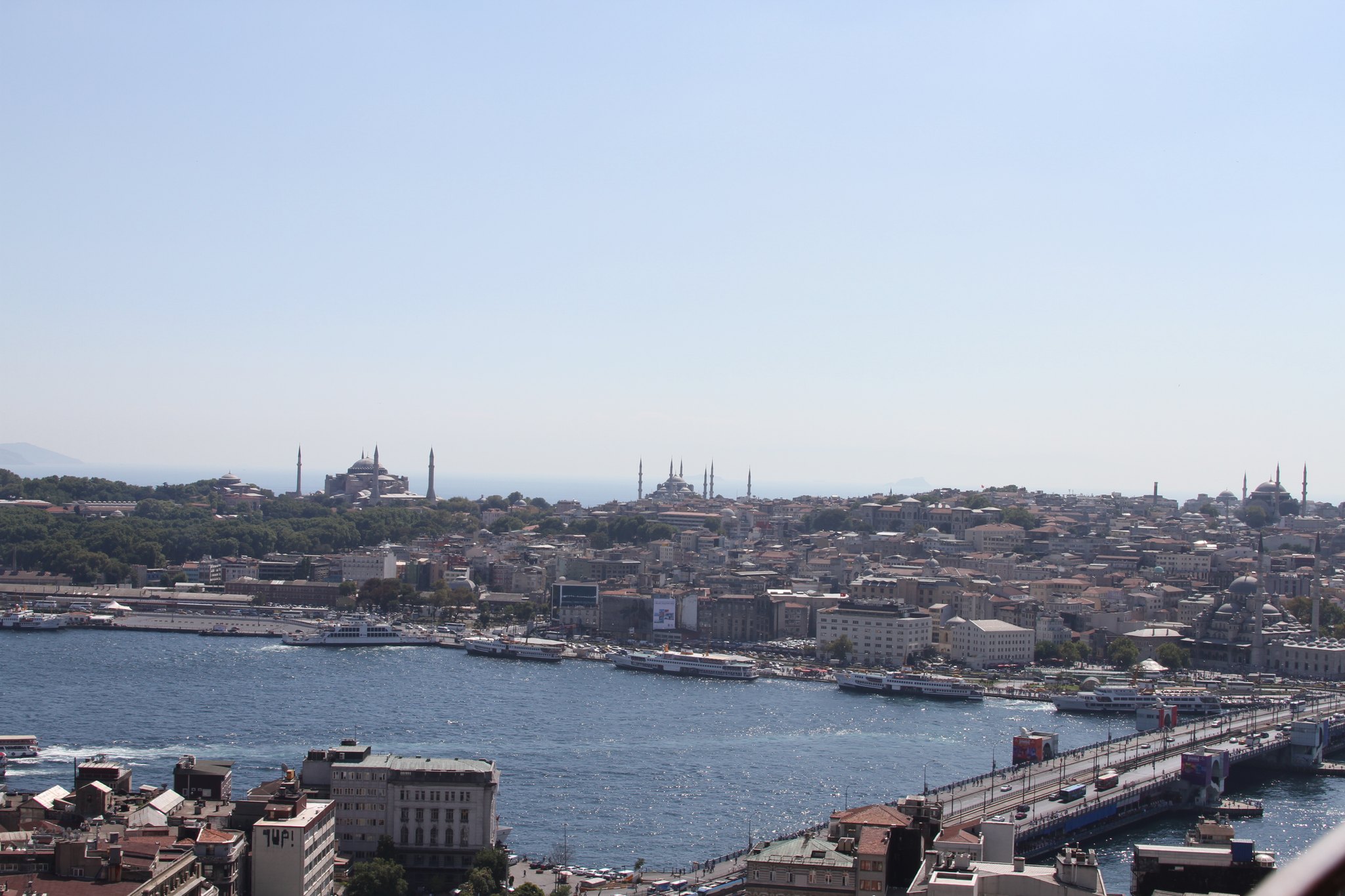 Ferries moored along the Eminonu piers, with more crossing the water behind them