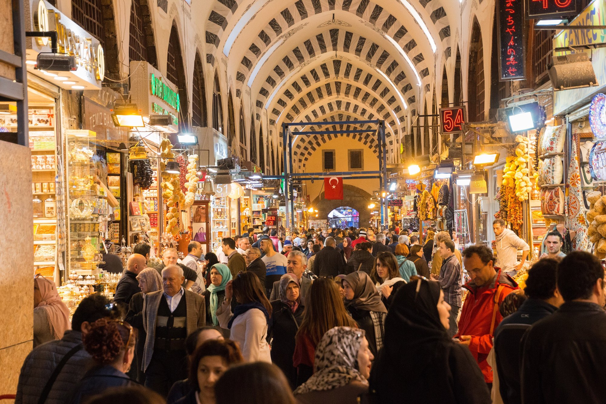 The Spice Bazaar's painted vault above a dense crowd, the L-shaped hall running away in both directions